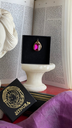 Colgante de bronce hecho a mano con cristal fucsia.