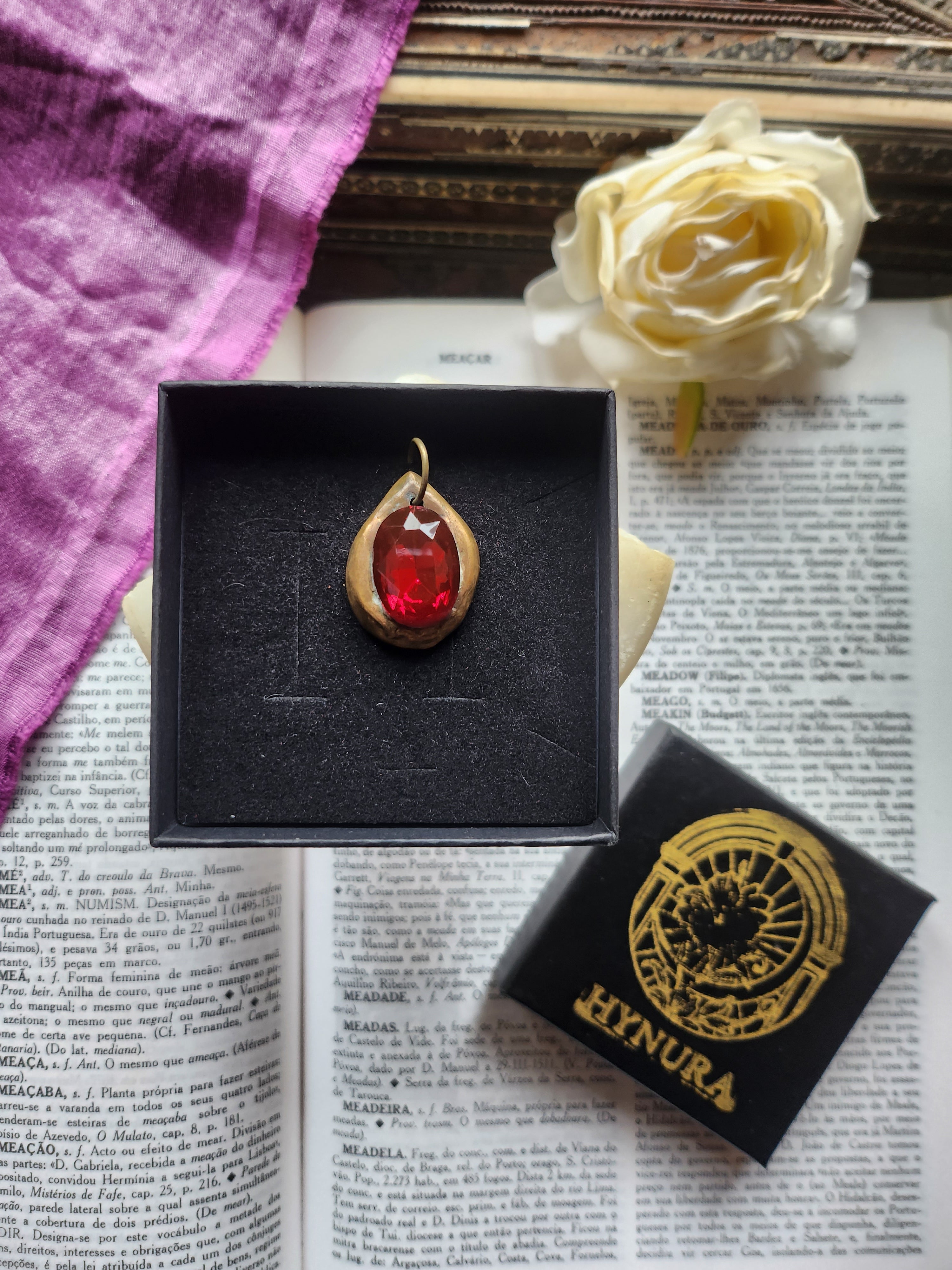 Colgante de bronce hecho a mano con cristal rojo intenso.