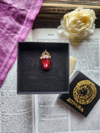 Colección Resonancia Arcana – Pequeño Colgante de Bronce Hecho a Mano con Cristal Ovalado Rojo Claro
